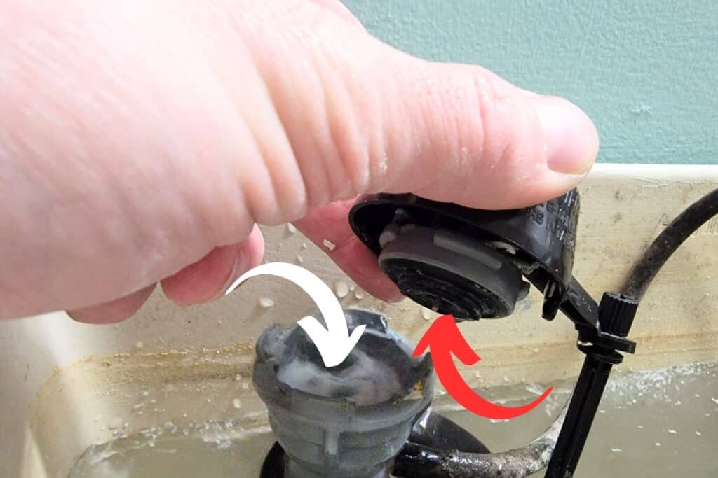 image of the author repairing a toilet fill valve to stop a randomly flushing toilet