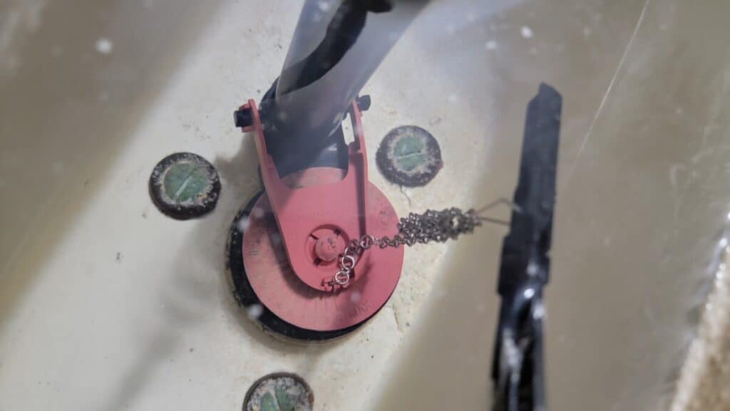 Image showing how much slack the chain should have when adjusting a flapper properly  in a toilet tank