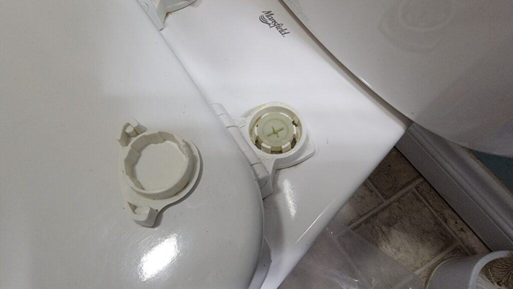 Image of a loose toilet seat because of plastic hardware.