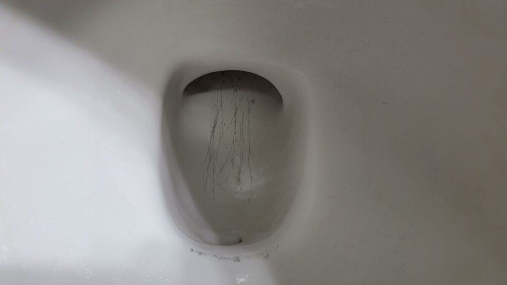 image showing metal scratches in a toilet bowl from a metal snake or auger.