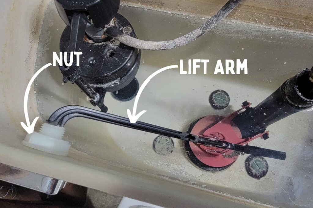 Image showing the nut that retains the toilet handle, and the lift arm which attaches to both the handle and the chain.