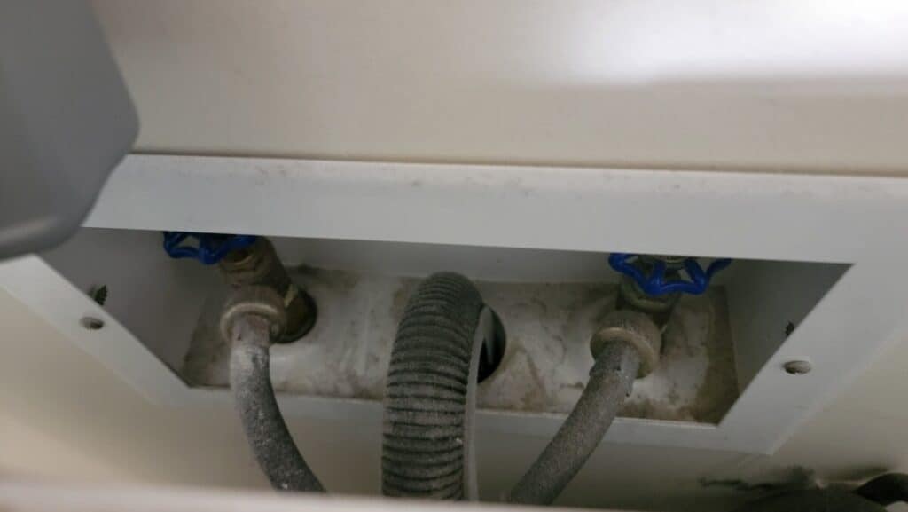 image showing how a washing machine drain hose should be installed to not cause the toilet to drain simultaneously. 