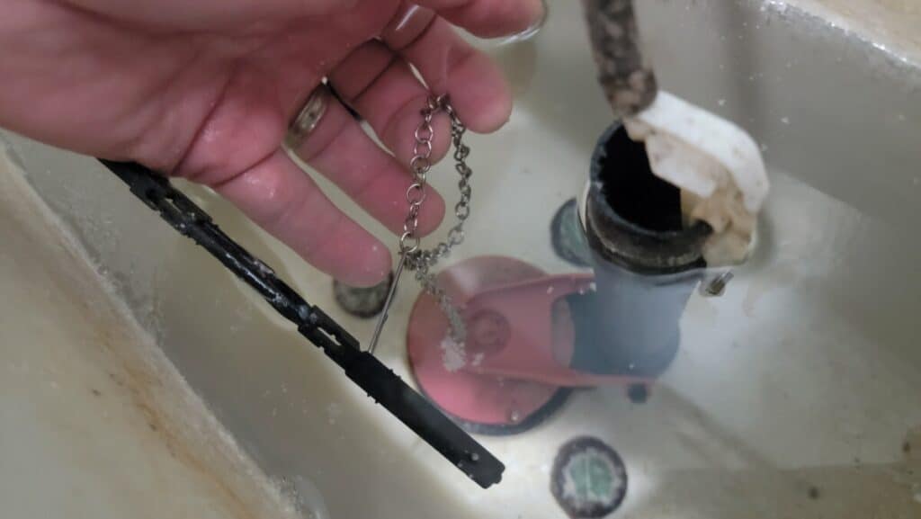 image showing how to adjust  the chain in a toilet properly for adjusting the flapper.