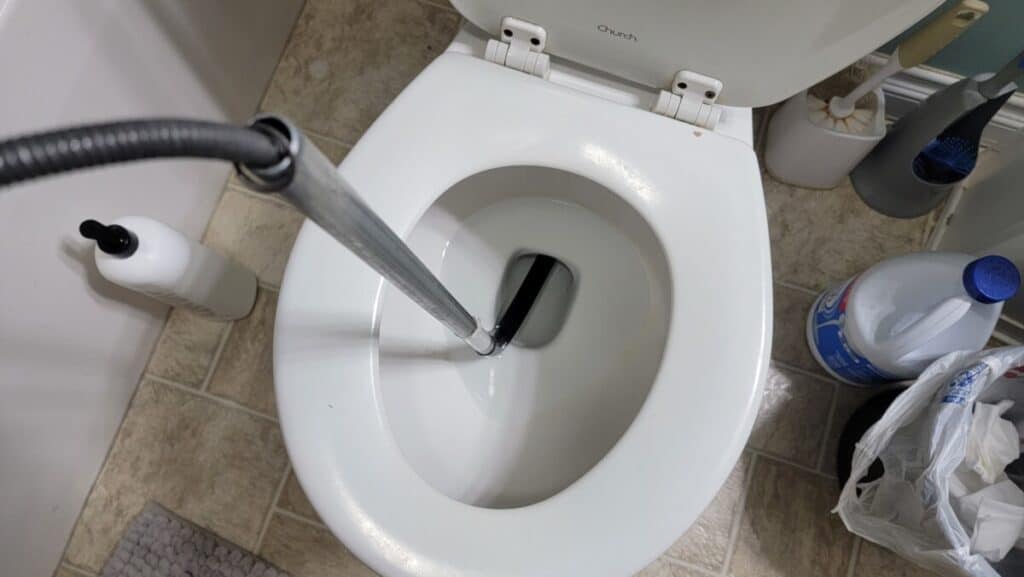 image of author using a toilet auger to remove bar of soap